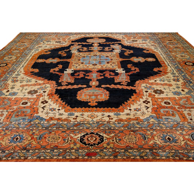 Beautiful antique Heriz hand-knotted wool rug with an orange rust color field. This Persian rug has dark blue and blue...