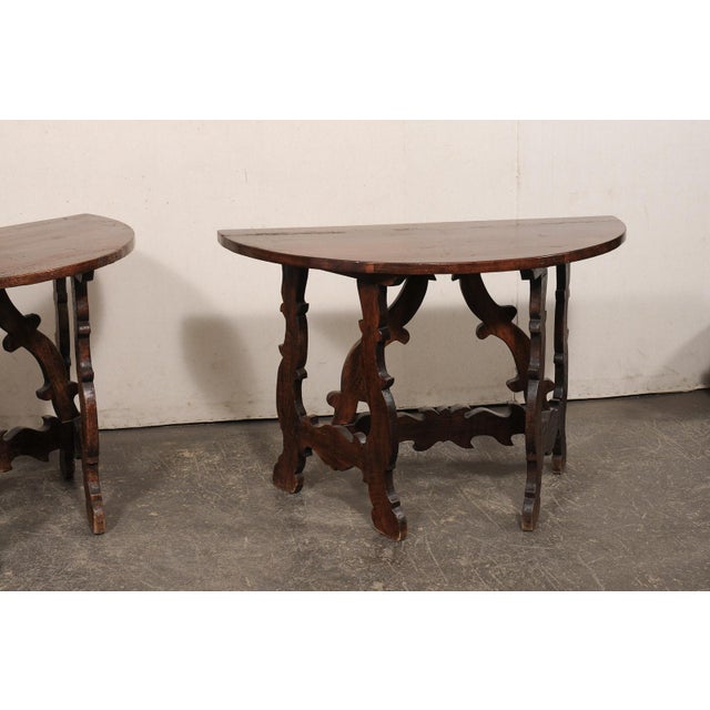 An Italian pair of carved-wood, Lyre leg console tables from the 19th century. These antique tables from Italy each...