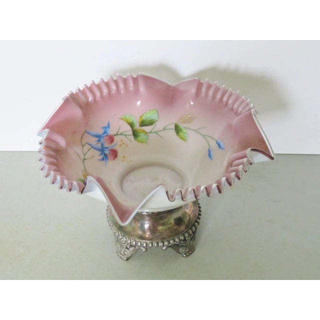 Enameled bowl with floral decoration and pink ribbon edge on a silverplate base.
