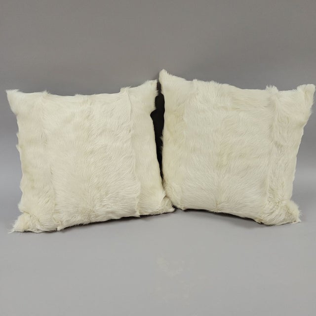 A pair of 2004 white fur pillows that are duck feather and down filled. We can't identify the fur, but it is...