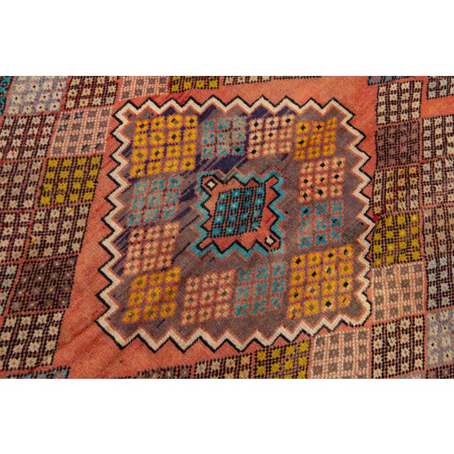 Beautiful Vintage Shiraz hand-knotted Wool rug with a peach color field. This piece has a beige frame and multicolor...