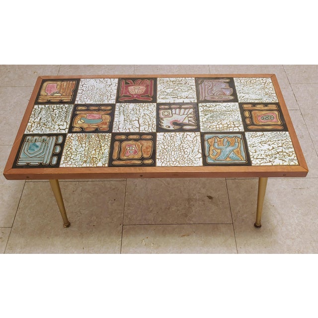 Here's a wonderful coffee table that was custom made in Brazil circa 1960s. It features abstract tiles and gold metal...