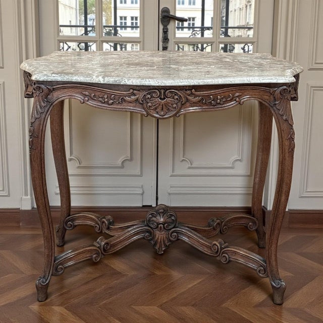 Early 20th century Louis XV marble top center table with a beautifully carved walnut base, shaped cabriole legs, and a...