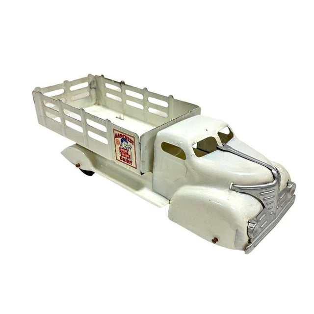 We have A white Marx Marcrest Pure Milk Dairy Truck modeled truck produced by Marx Toys, a prominent American toy company...