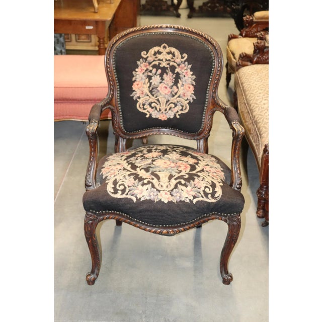 This is a charming armchair in the Louis XV taste and is French with a beautifully done brown multi colored needlepoint....