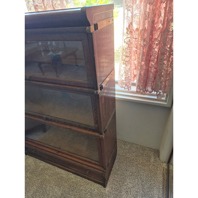 This is an antique Globe-Wernicke wooden barrister bookcase featuring a modular design with three stackable glass-front...