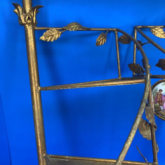 Pair of English gilded metal spiral staircase wall-mounted shelves with polychrome porcelain plaques.