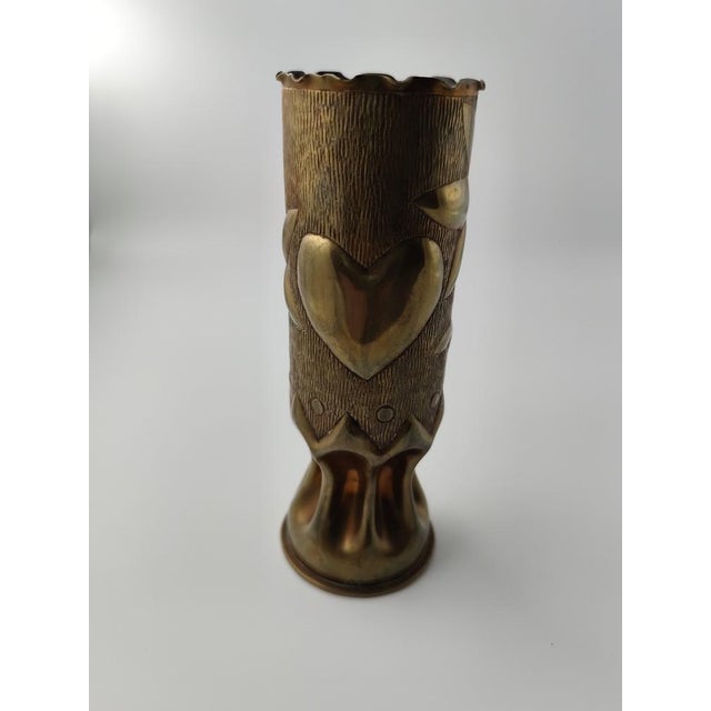 This object is an old cartridge case that has been transformed into a vase. This transformation of military objects into...