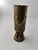 This object is an old cartridge case that has been transformed into a vase. This transformation of military objects into...