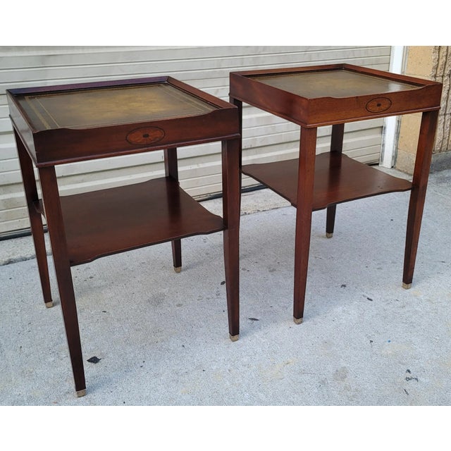 Featured is a very traditional looking pair of vintage Two Tiered Leather Top Side Tables. Tapered legs terminating in...