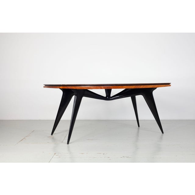 Dining table, Italy, 1950s Elegant dining table with a sculptural, black lacquered wooden frame. The tabletop is...