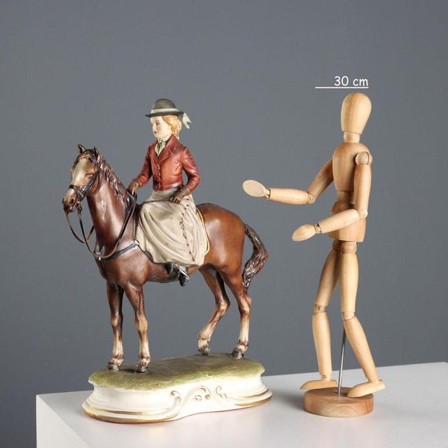 A young woman on horseback in polychrome ceramic, an elegant and refined sculpture. The base bears a manufacturer's mark...