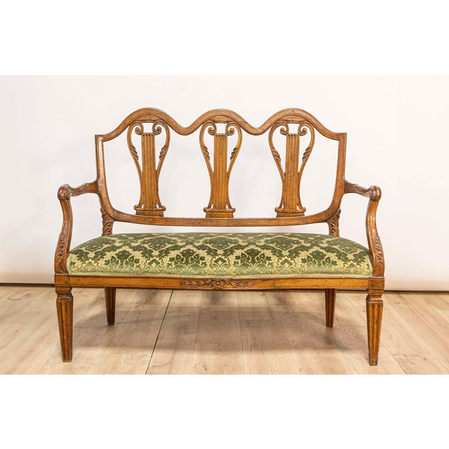 A Florentine walnut sofa from the 18th century from the Villa Fioravanti, with carved lyre motifs, scrolling arms and...