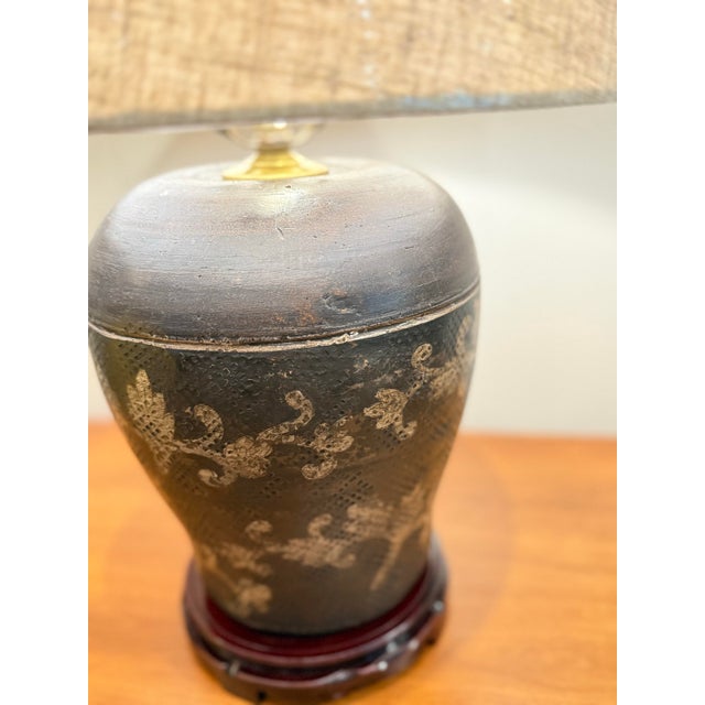 Ruggedly, handsome aged brown pottery urn as lamp has carvings that are highlighted by new wiring and new linen drum...