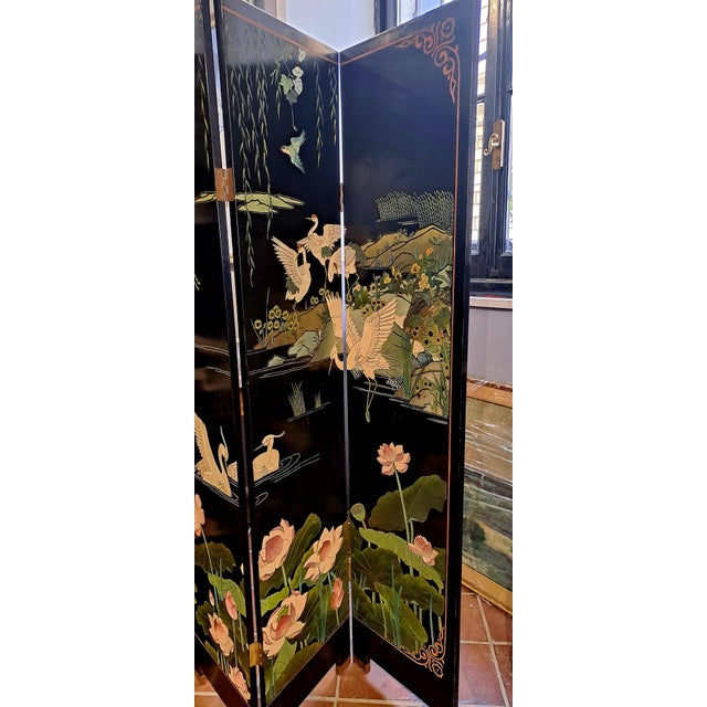 Large six-panel screen in black lacquer. On one front naturalistic depictions with storks and lotus flowers made with an...