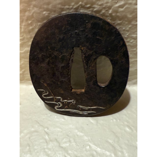 wn a genuine piece of samurai history. This authentic Japanese Edo-period tsuba (sword guard) showcases an elegant floral...