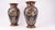 Bold polychrome strapwork ribbons in opaque pink and pale green enamel curve across the body of each vase, standing in...