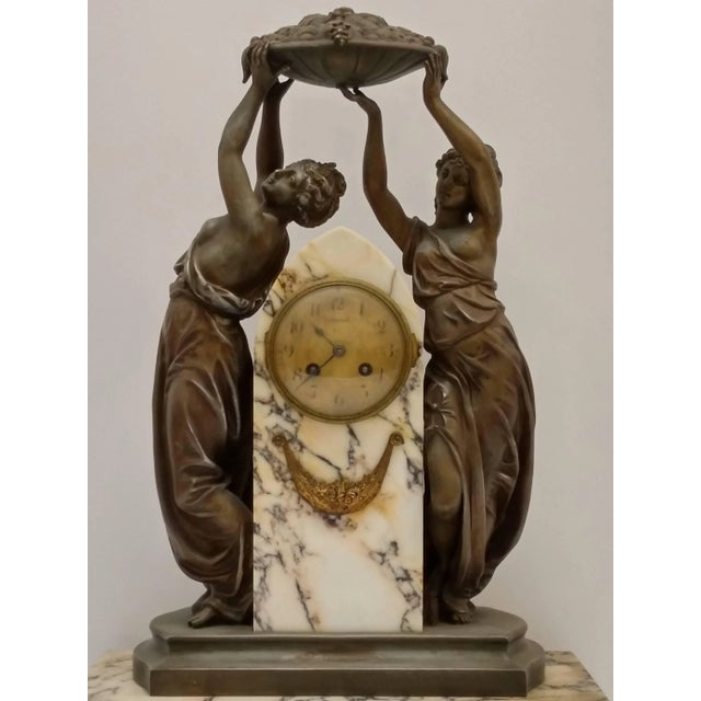 French Art Nouveau sculpture with a clock decorated with a pair of women rejoicing in the harvest of the season. We are...