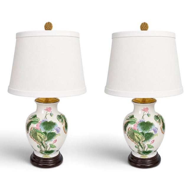 This is a pair of Chinese export ceramic lotus and floral table lamps. They have 6 inch wooden bases and brass caps. It is...