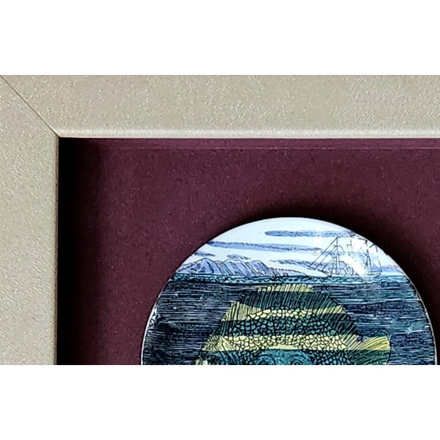 Piero Fornasetti “12 Mesi, 12 Soli” Porcelain Coaster, April, Sun as a Fish, Framed Milan, circa 1960–1965 This porcelain...