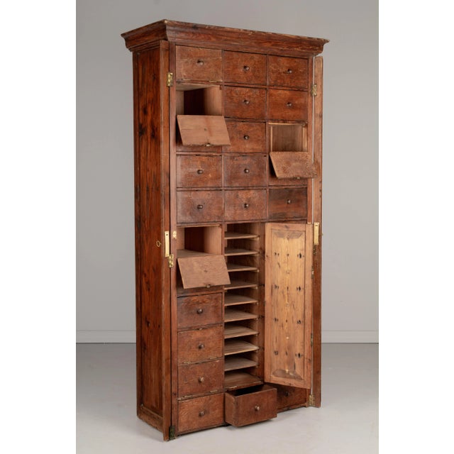 An early 20th Century rustic French cartonnier or cabinet with many compartments, likely used as a store fixture or office...
