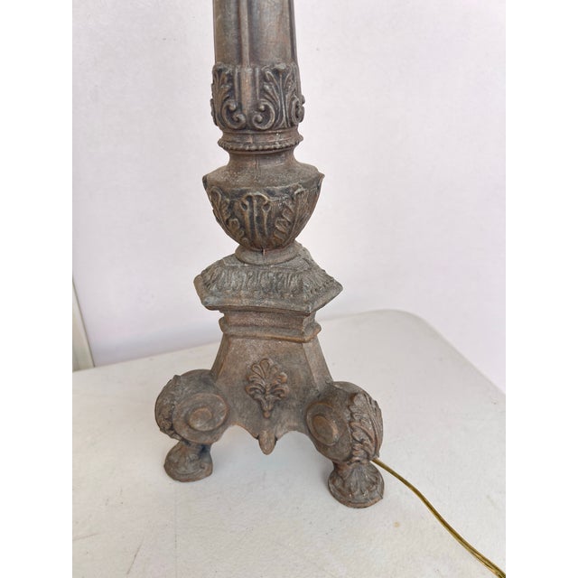 This cast metal candlestick table lamp features a Neoclassical-inspired design. Featuring intricate relief details of...