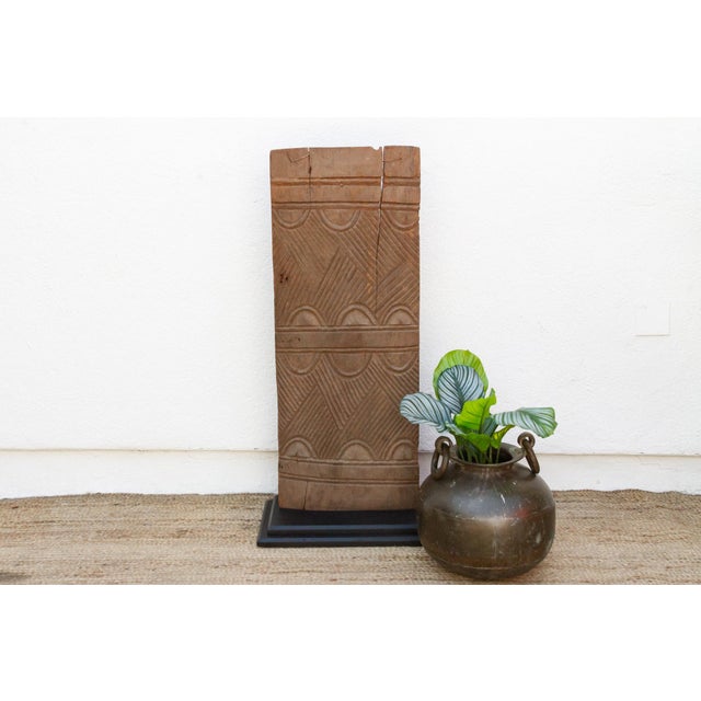 Carved from two adjoining planks of hardwood and joined along their length with cord lashings — a construction method...