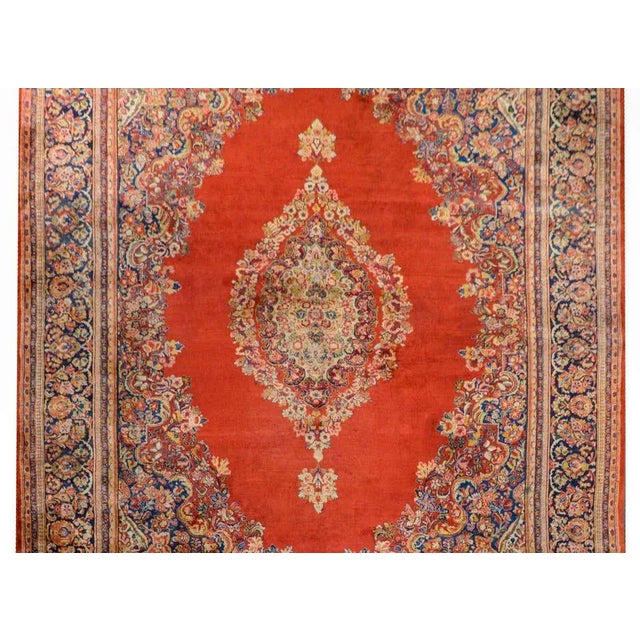 An outstanding monumental early 20th century Persian Sarouk rug with a large floral medallion woven in myriad colors...