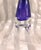 This is a very unusual art glass perfume bottle. The bottle itself is purple and that bottle sits in or on a clear base or...