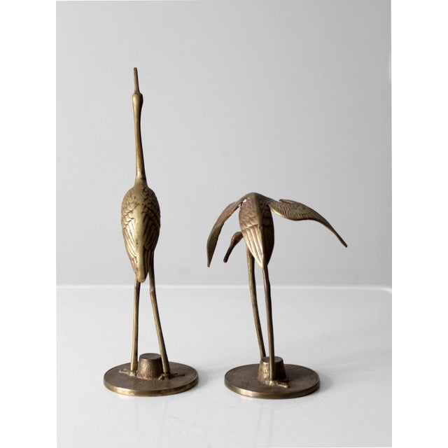 This pair of mid-century brass cranes showcases intricate detailing, capturing the graceful elegance of long-legged water...
