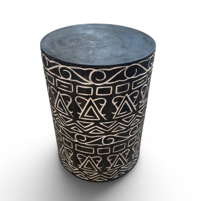 This carved African stool is a handcrafted seat or small side table made from wood and decorated with carved patterns,...