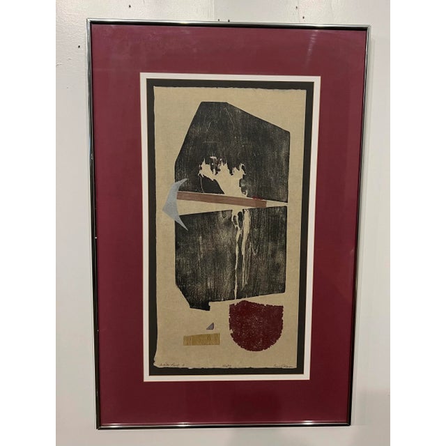 Framed and matted artwork made by stamping found items. Signed and dated from 1979.