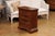 An Italian walnut bedside chest from circa 1840 with burl wood panels, four drawers and carved bracket feet. Immerse...