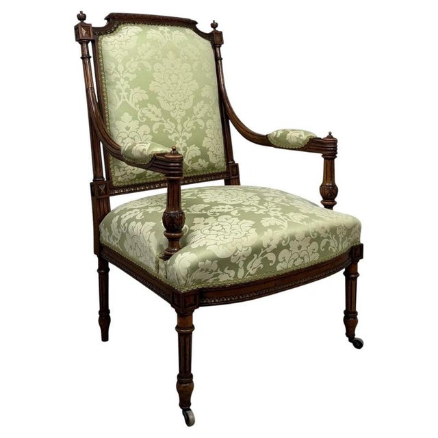 An elegant 19th century French open armchair, finely crafted in walnut and distinguished by its graceful proportions,...
