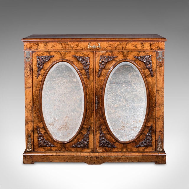 This is an antique morning room book cabinet. An English, walnut and burr walnut mirror front bookcase, dating to the...