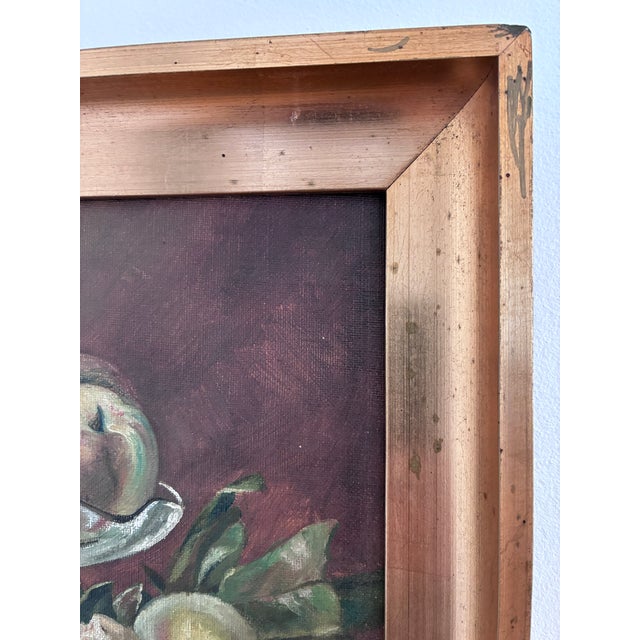 This antique original oil painting from around the 1920s shows a still life of peaches arranged in a glass dish,...