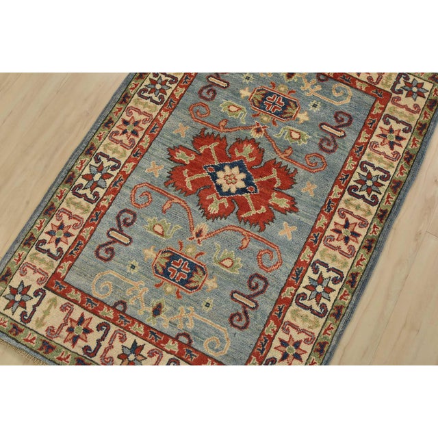 A tribal Caucasian Kazak rug hand-knotted with fine wool on a cotton foundation. This rug features a central medallion...