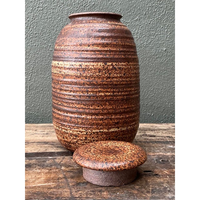 This exceptional piece of original studio pottery is a masterclass in organic texture and earthy design. The lidded vessel...
