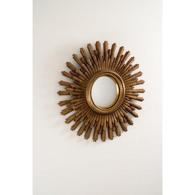 This vintage sunburst wall mirror is a classic representation of Mid-Century Modern and Hollywood Regency design. Crafted...