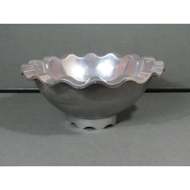 A strong postmodern centerpiece with a soft, rhythmic silhouette—this footed bowl features an undulating rim that catches...