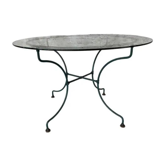 Mid-Century Wrought Iron Patio Table and Four Chairs in the style of Salterini. 48"Diameter x 30"H round table has a...