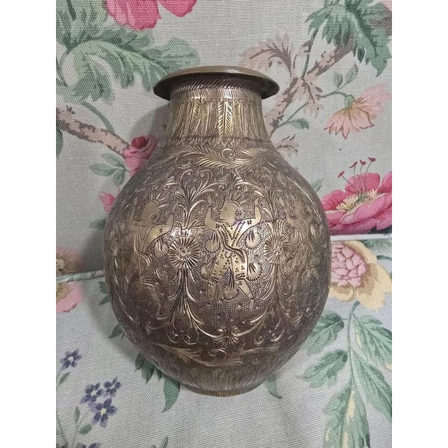 This intriguing antique brass vase from the 19th century showcases exquisite hand-engraved detailing, featuring exotic...
