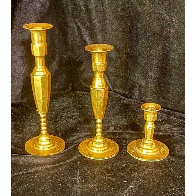 This set of three vintage brass candlestick holders features classic mid-century geometric designs and tiered, beaded...