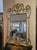Georgian-style mirror. Elegant decorated wooden mirror. Lacquered wooden frame with gold-leaf decorations and curls....