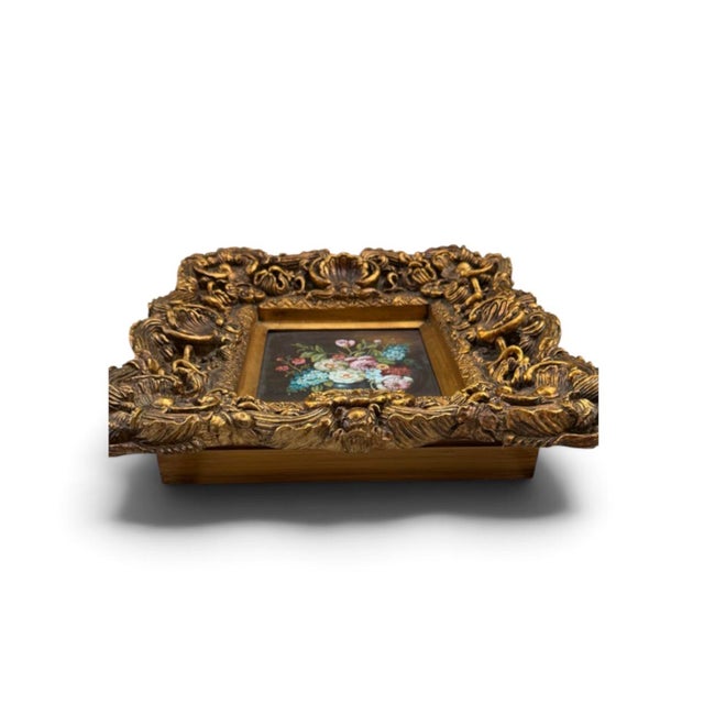 A richly detailed vintage floral still life presented in an exceptionally ornate gilt frame. The hand-painted composition...