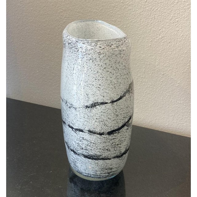 This intriguing vase, made by Belgian glass artist Henry Dean, is made of recycled glass. The white section of the vase is...