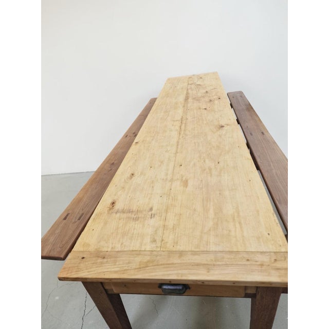 A long, rustic-style table topped with two matching trestle benches. Here's an explanation of what makes this furniture so...