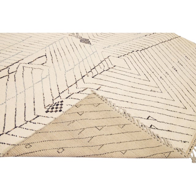 Beautiful Moroccan style handmade wool rug with a beige field. This Modern rug has gray accents featuring a gorgeous all-...