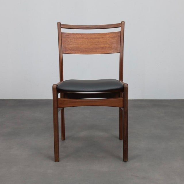 A rare set of four mid-century modern dining chairs crafted in the 1960s, executed in beautifully grained teak and...
