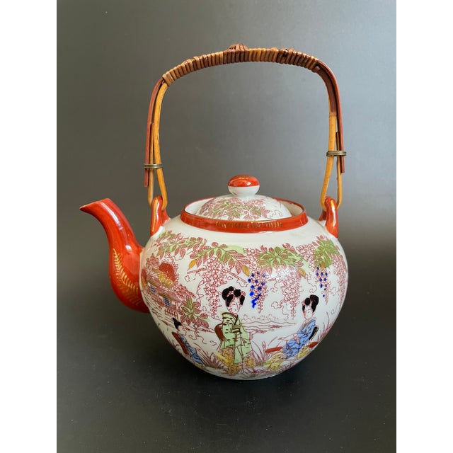 This antique Kutani eggshell porcelain tea set includes a teapot and a matching teacup trio, featuring hand painted geisha...